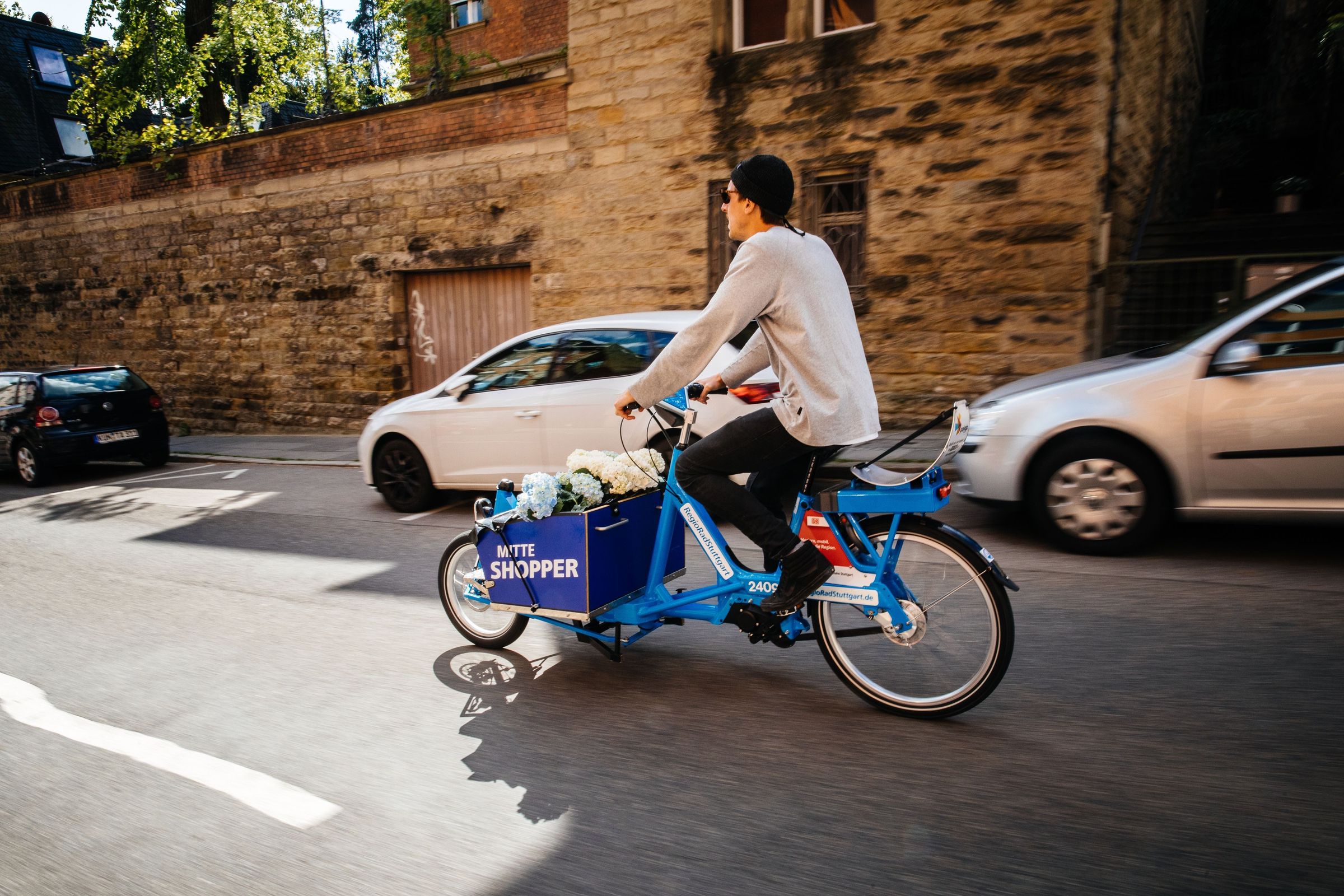 Man transports flowers on RegioRadStuttgart cargo pedelec on the road