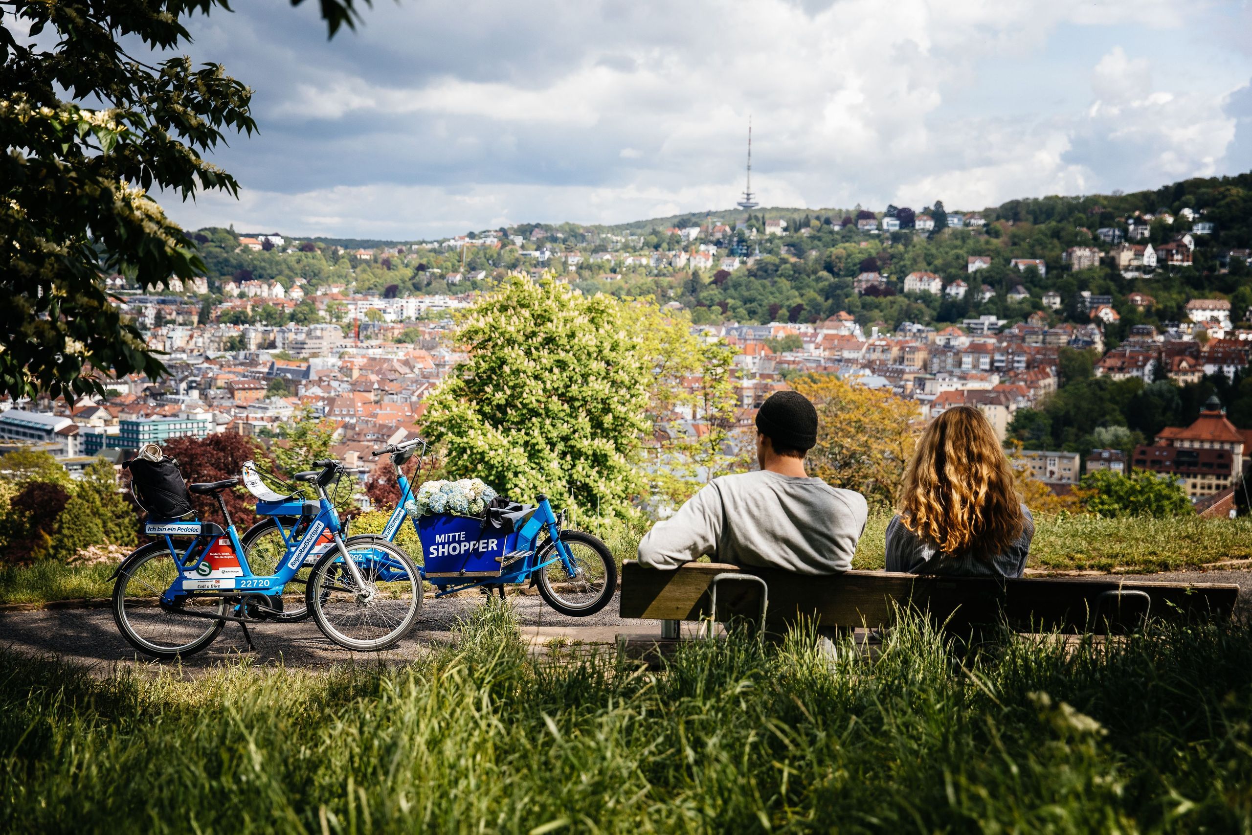 Zwei Menschen mit einem RegioRadStuttgart Pedelec und Lastenpedelec machen Pause auf einer Aussichtsplattform in Stuttgart