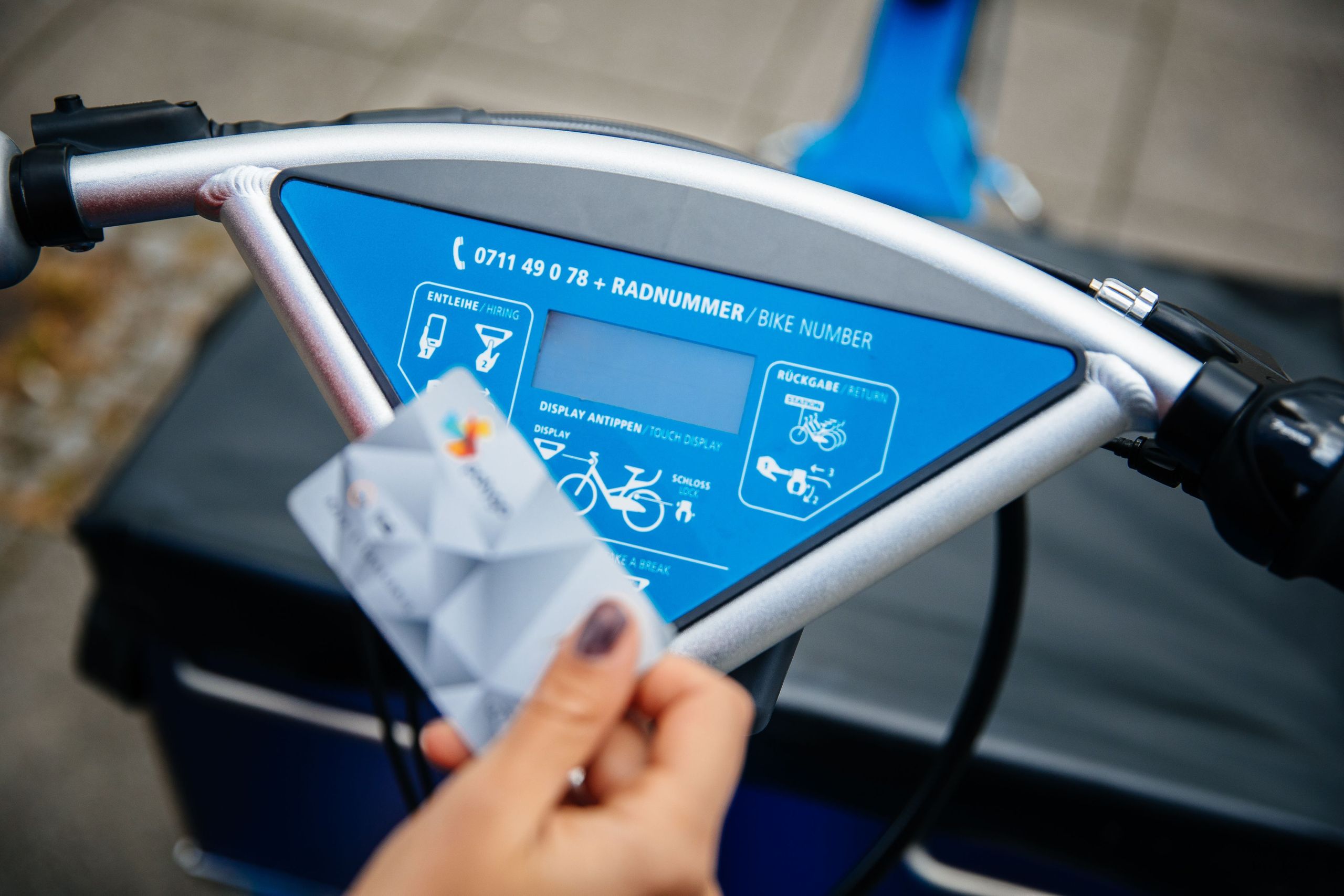 Frau hält ihre polygoCard vor Lenderdisplay des RegioRadStuttgart Lastenpedelecs in der Hand